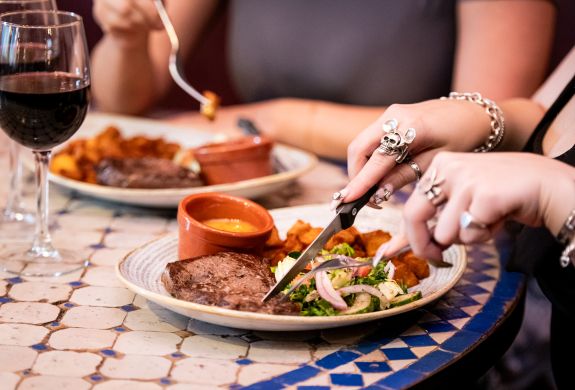 two ladies enjoying a steak meal and bottle of house wine at revolución de cuba