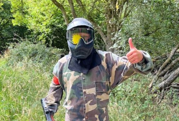 Person with thumbs up and paint on helmet