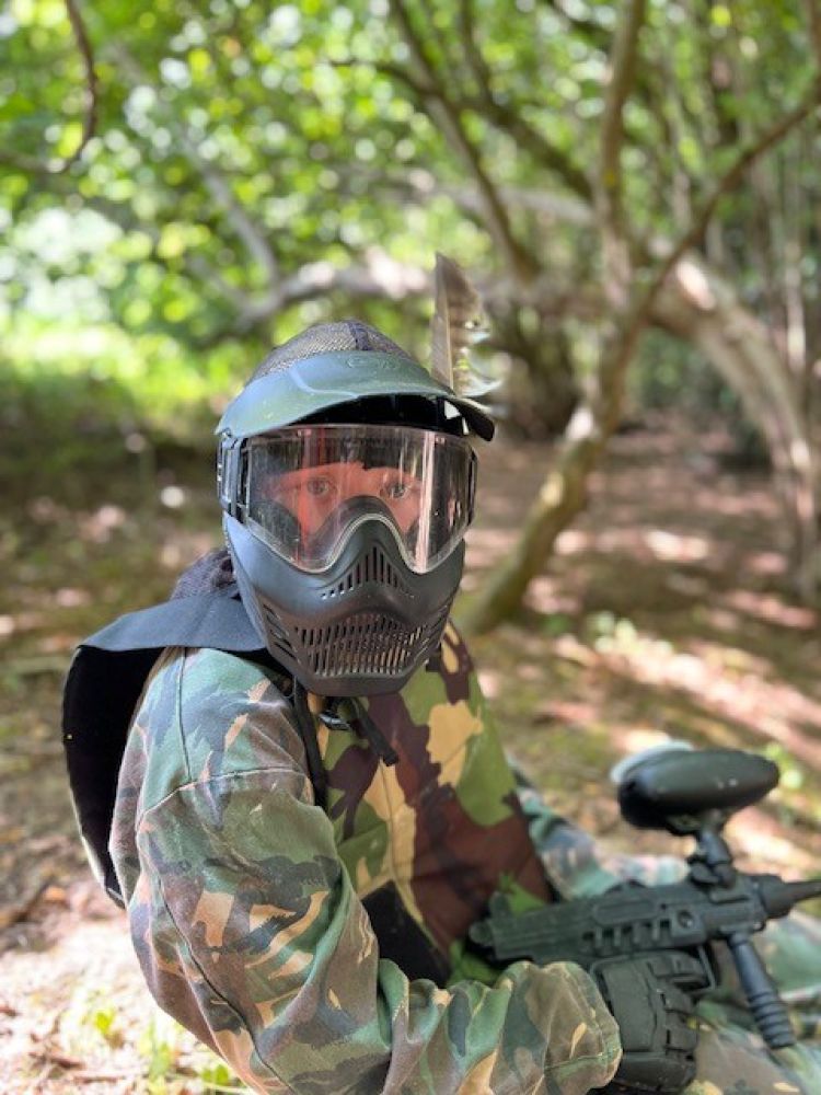 Young person in helmet playing paintball
