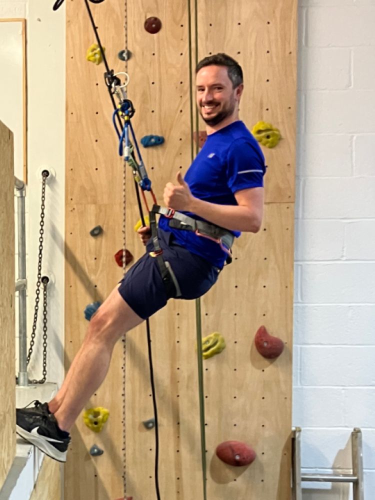 man abseiling down an indoor wall on an abseiling taster session in brighton