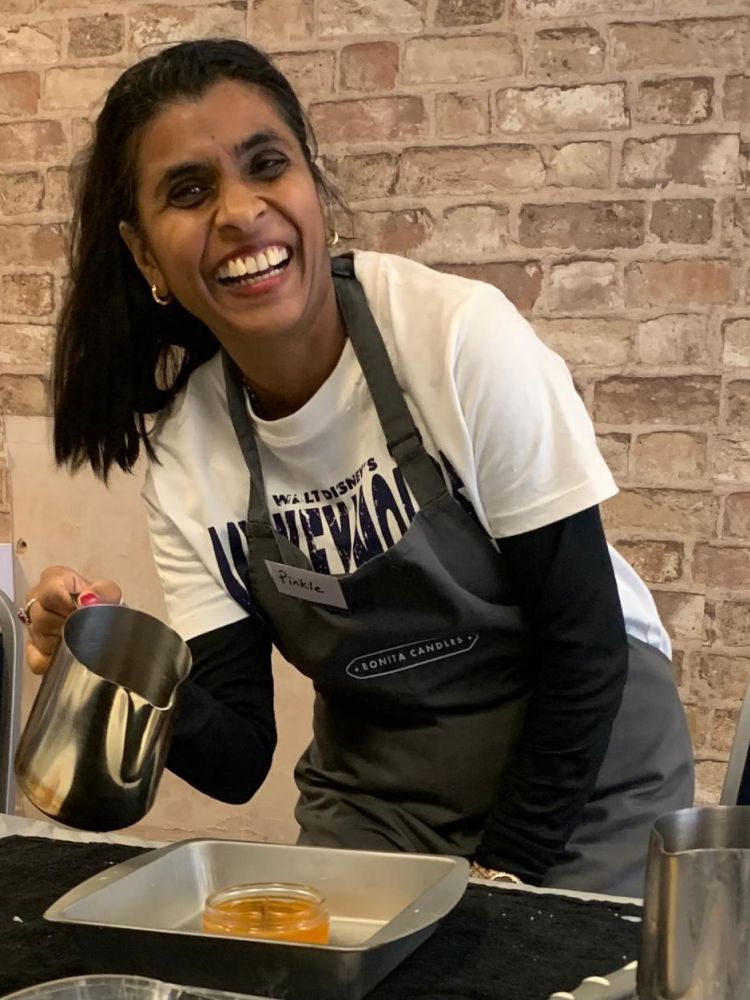 Woman smiling making a candle at a candle making workshop