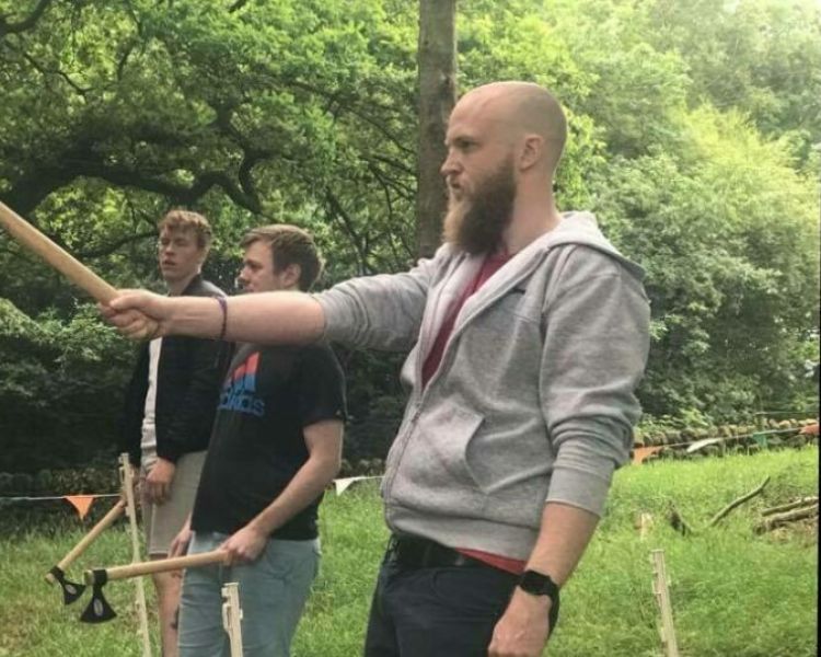 man preparing to throw an axe at the target on an axe throwing experience day