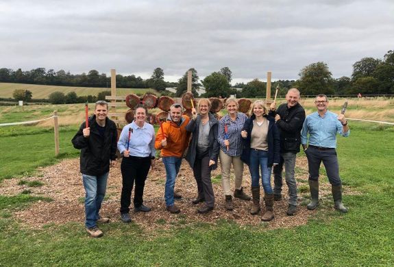 Group of people posing with axes on an axe throwing experience