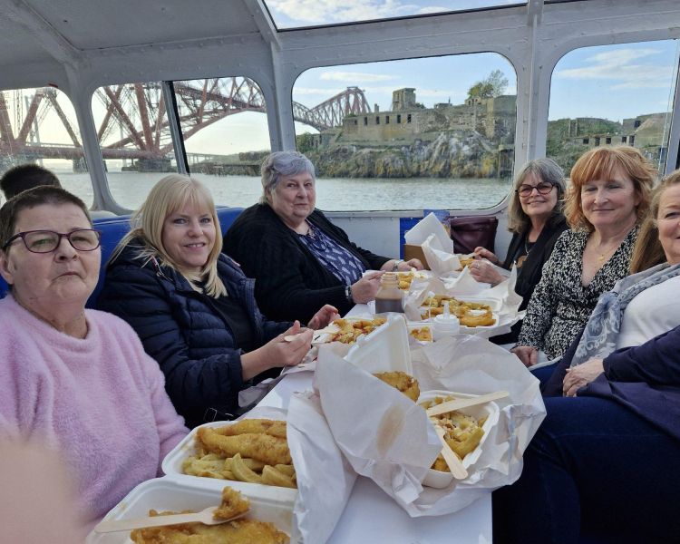 people enjoying fish and chips on a river cruise