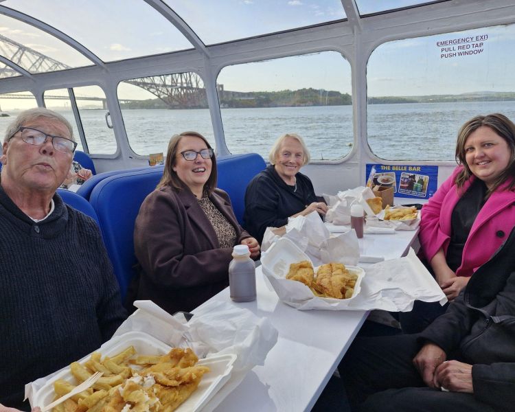 people enjoying fish and chips on a rive cruise