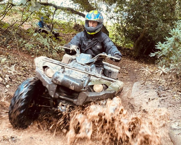 person riding quad bike through water on course in devon