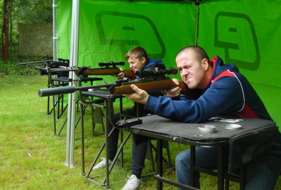 man and boy shooting air rifles on a target shooting experience