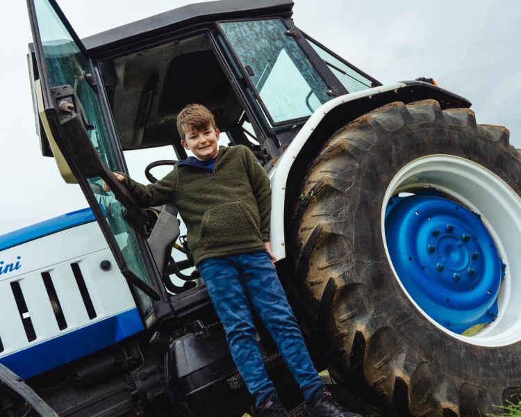 young boy in front of lamborghini tractor on a family driving day experience