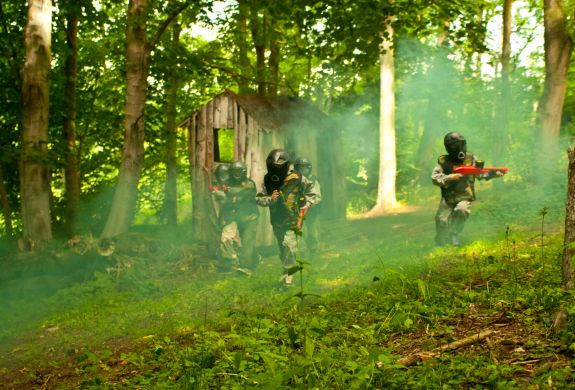 kids playing paintball in forest