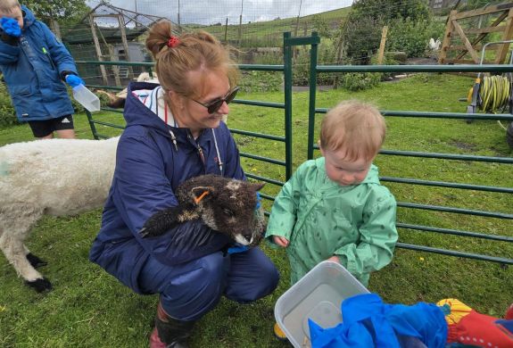 mum and young boy feeding sheep on a west yorkshire farm