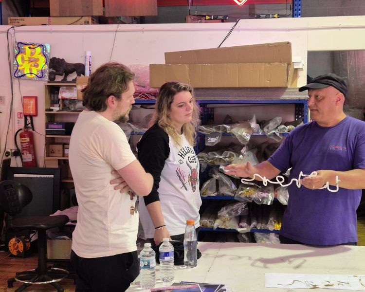 two people watching man explain neon signs on neon sign taster session