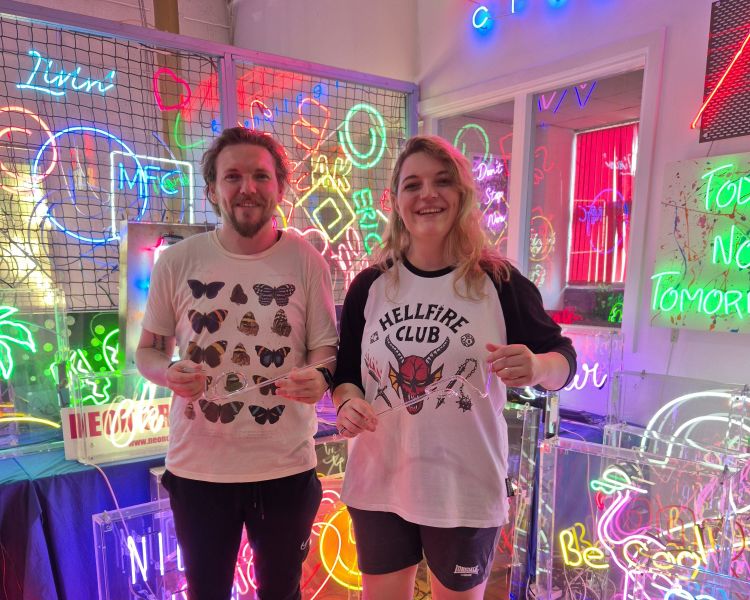 couple with their bent glass on neon sign taster session