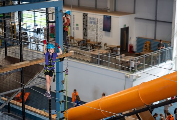 girl on indoor high ropes course at activity centre in wales