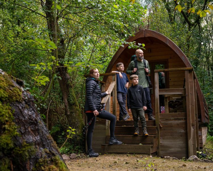 family outside a wooden pod at activity centre in wales on overnight stay