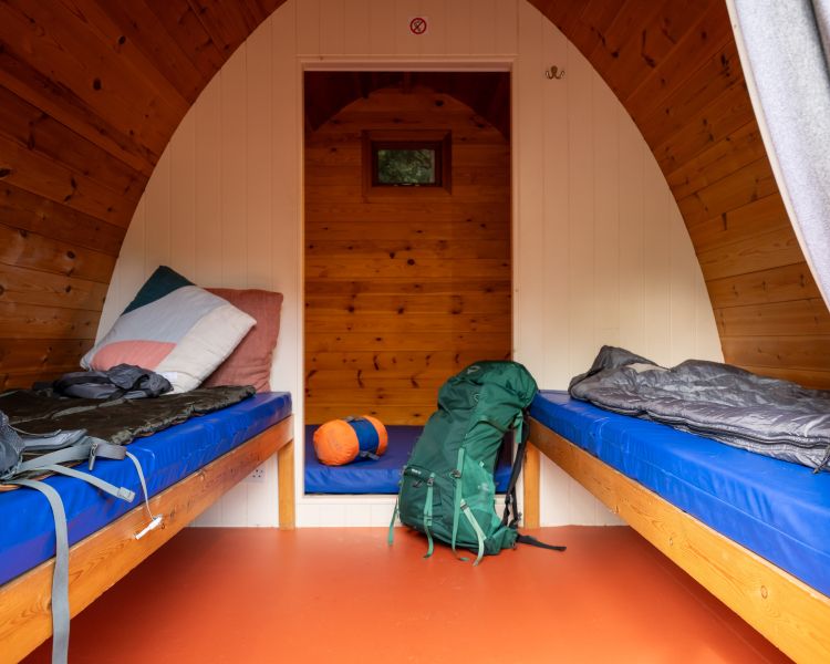 inside a wooden pod showing beds at activity centre in wales for overnight stay