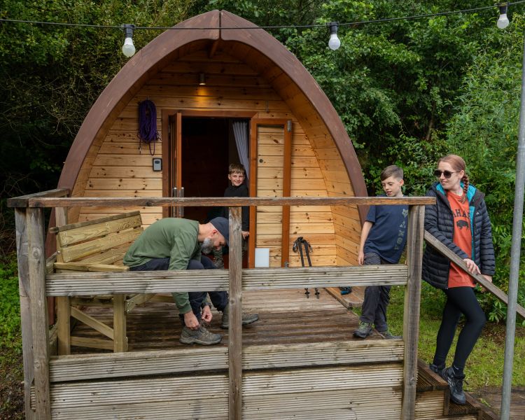 family getting ready to leave their wooden pod at activity centre in wales