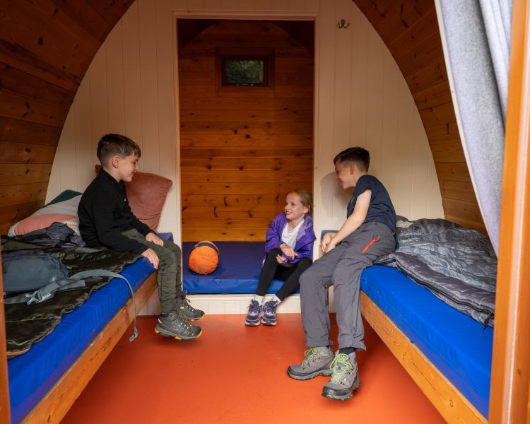 kids inside wooden pod at activity centre in wales for overnight stay