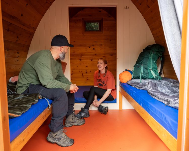 couple inside wooden pod at activity centre in wales for overnight stay