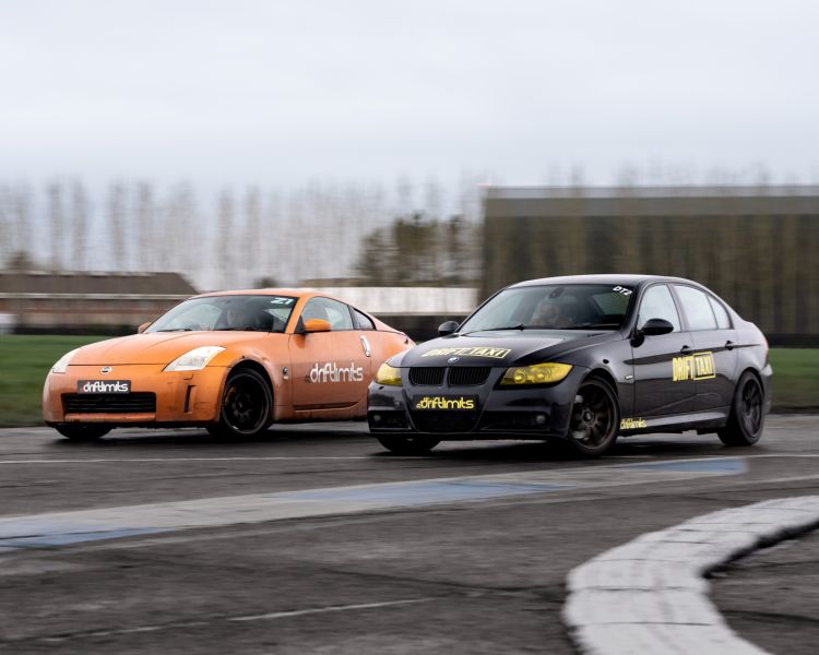 drift battle between nissan and bmw sports cars on a race track