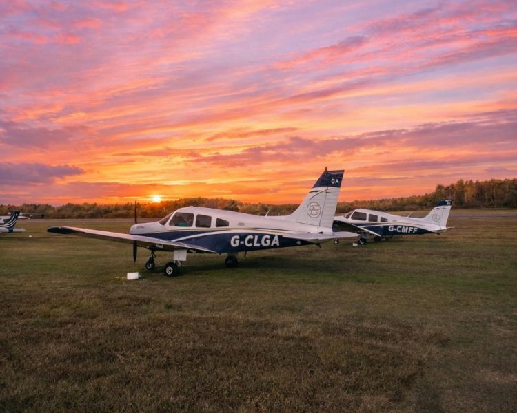 Sunset over two parked planes on airfield