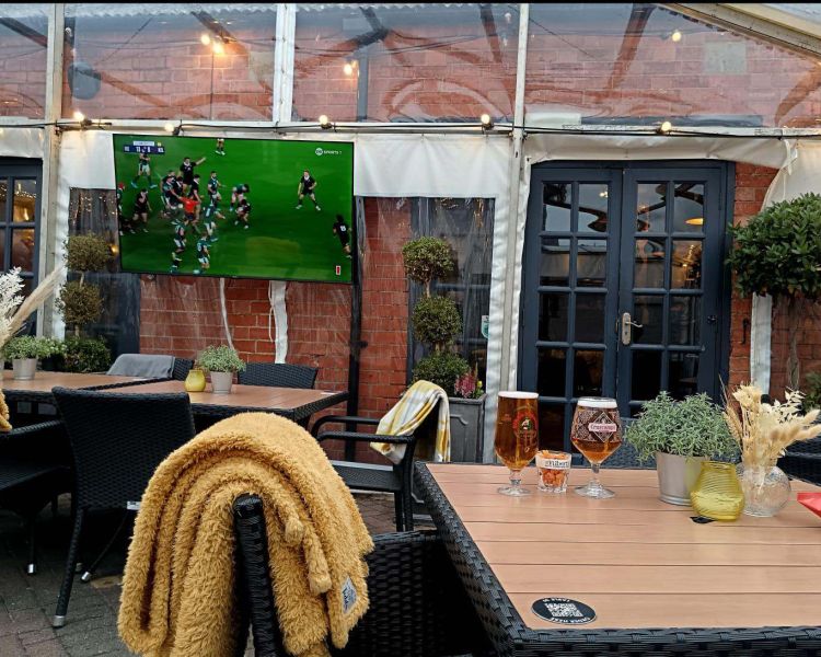 Bar outdoor area with drinks and a tv