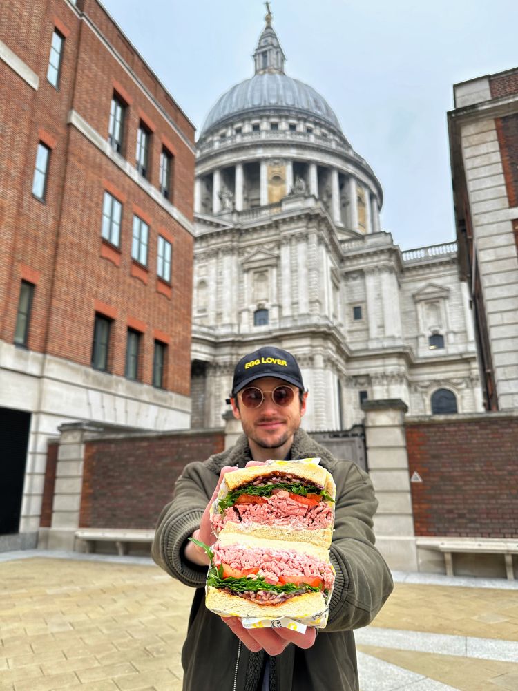 Man holding sandwich on a food mystery tour in london