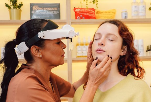 Facialist looking at clients skin
