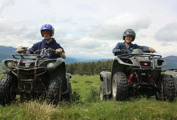 two people on quad bikes on a hill side on a quad biking experience day
