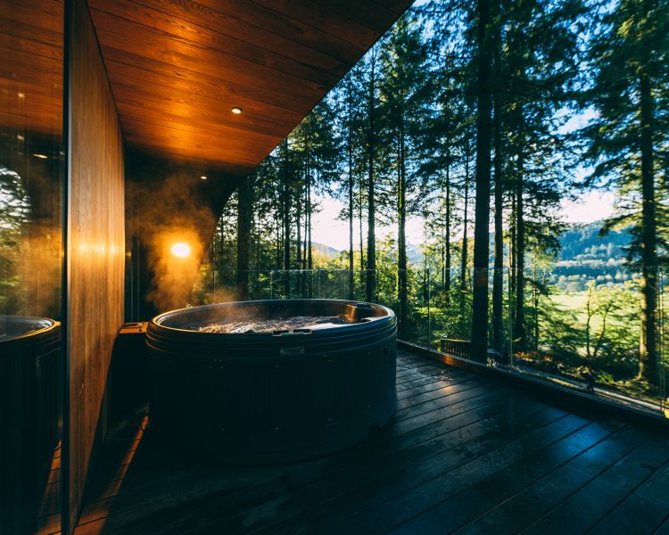 Outdoor hot tub on balcony at forest lodge