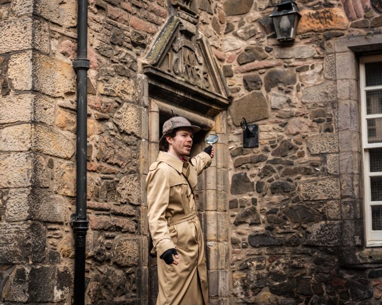 guide pointing to building on a historical walking tour in edinburgh