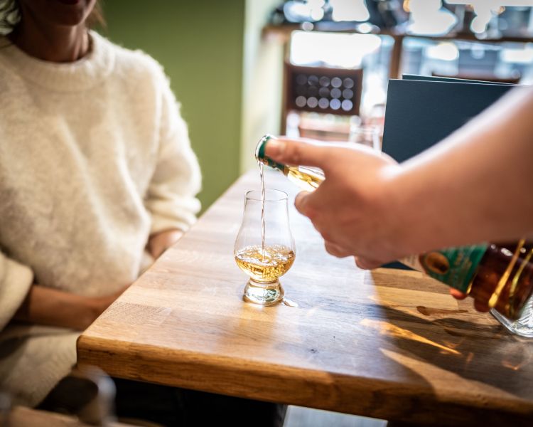 pouring whisky for tasting on a historical walking tour in edinburgh