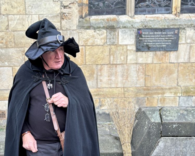 guide by wall plaque on a witches walking tour in york