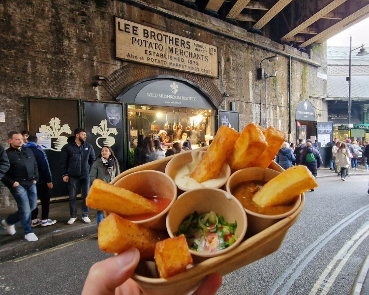 Chips and dips held up in front of chip vendor in borough market