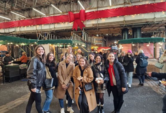 Tour group posing for photo inside londons borough market on a food tour