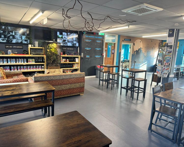 the lobby area with tables and chairs at an adventure centre