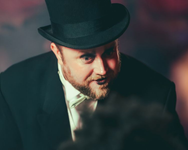 actor dressed as magician at chat noir immersive show and dining experience in london