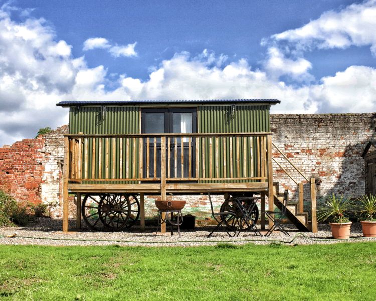 a green shepherds hut in the walled garden of a shropshire estate