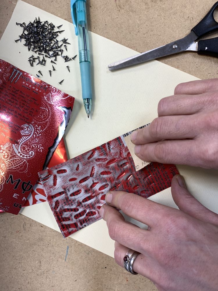 cutting and texturising metal from recycled drinks cans to make letters