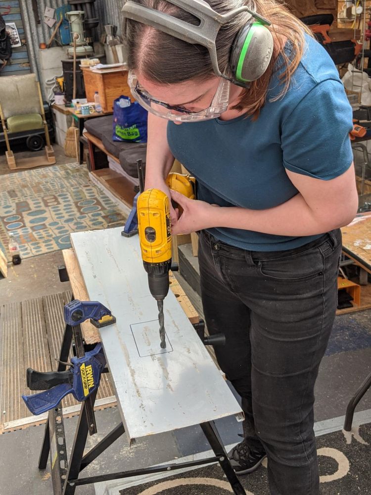 woman drilling wood in workshop on a campervan conversion course