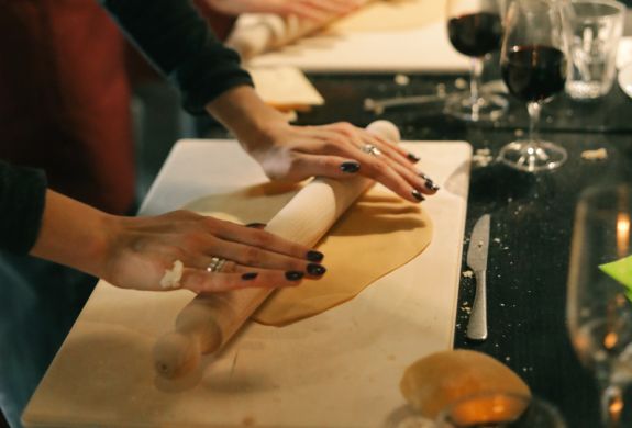 Students rolling pasta dough at pasta making class