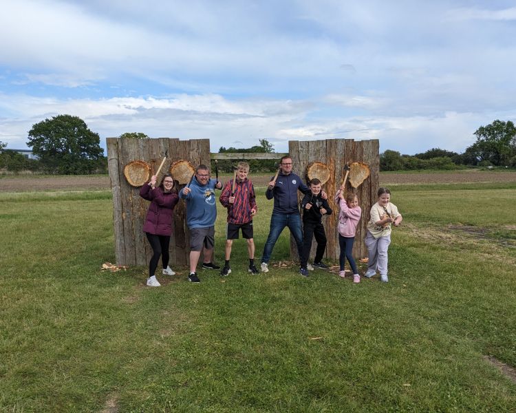 group posing with axes on an axe throwing experience