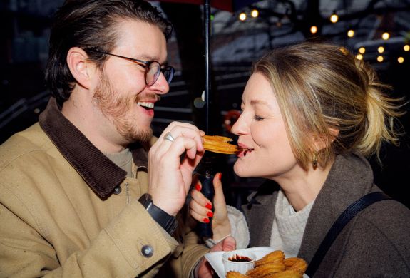 Couple eating churros on a food treasure hunt in manchester