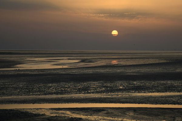 the sun setting on the coast in the wirral