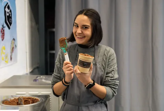 woman smiling and holding a tub of gelato on a learn how to make gelato workshop in london