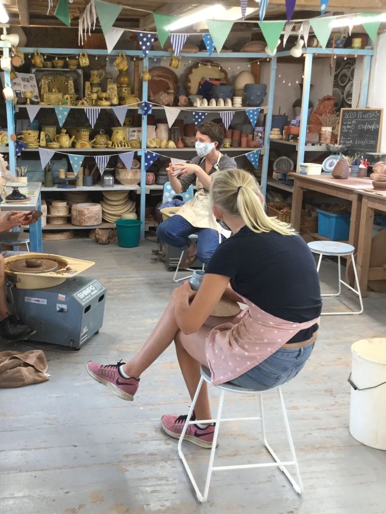 a pottery workshop with people at potters wheels on a pottery course experience day