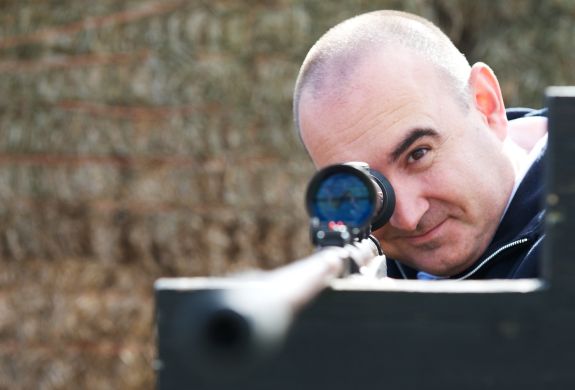 man aiming an air rifle while on a spy camp experience day for adults