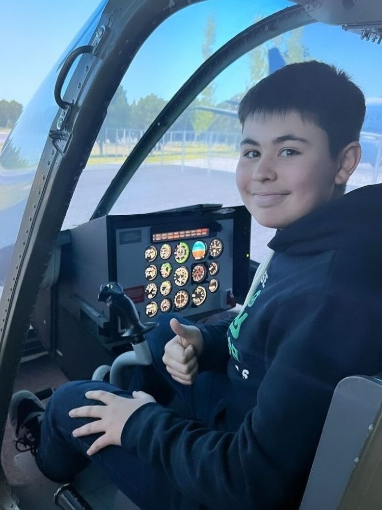 young boy in the cockpit of a jet ranger helicopter flight simulator