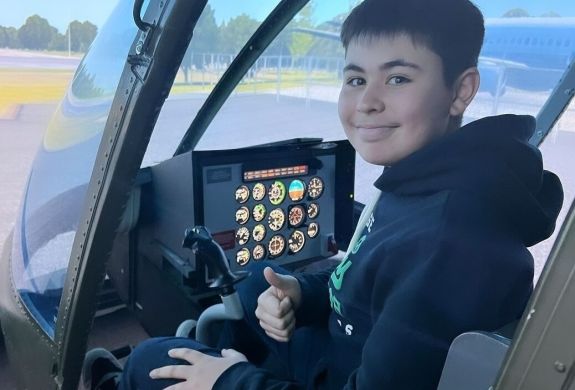 young boy in the cockpit of a jet ranger helicopter flight simulator