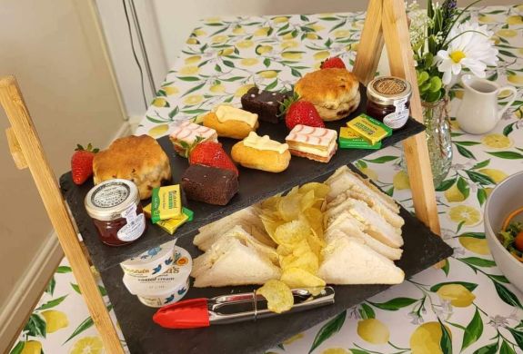 an afternoon tea displayed on a cake stand on a table in the tea room of little skipworth carriage rides