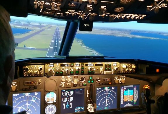 the cockpit of a boeing7371 flight simulator and the view of the runway